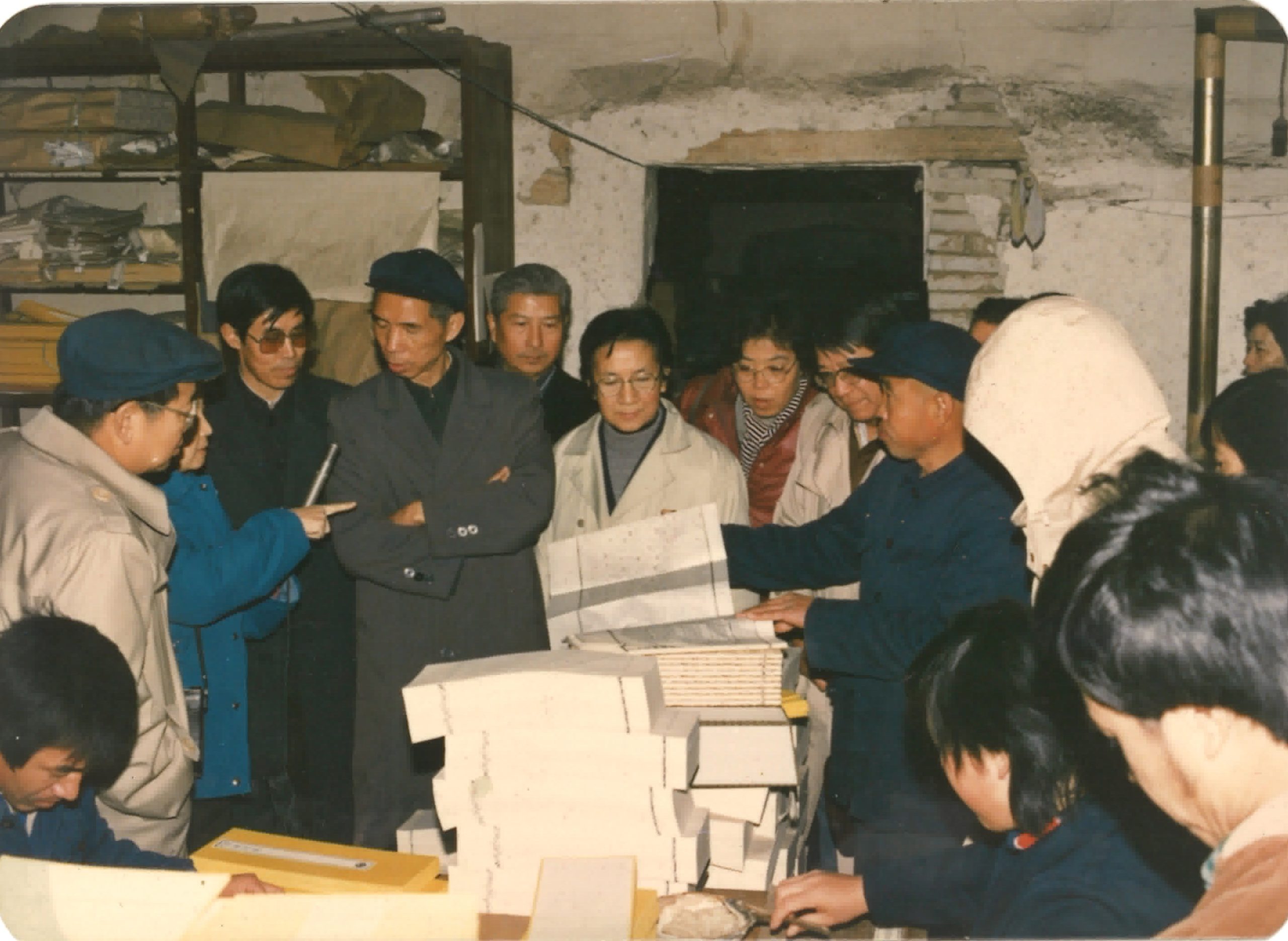 Wang Daiwen (fifth from left), President of Three Generations Ren Zhixiang Cultural Relics Publishing House, introduced the brush version of the Long Zang Jing (shooting time: 1987 Location: Beijing Huayizhai Ancient Books Printing Co., Ltd. Photographer: Ren Baoquan Content: Wang Daiwen, President of Three Generations Ren Zhixiang Cultural Relics Publishing House (fifth from left) introduced the brush version of the Long Zang Jing.